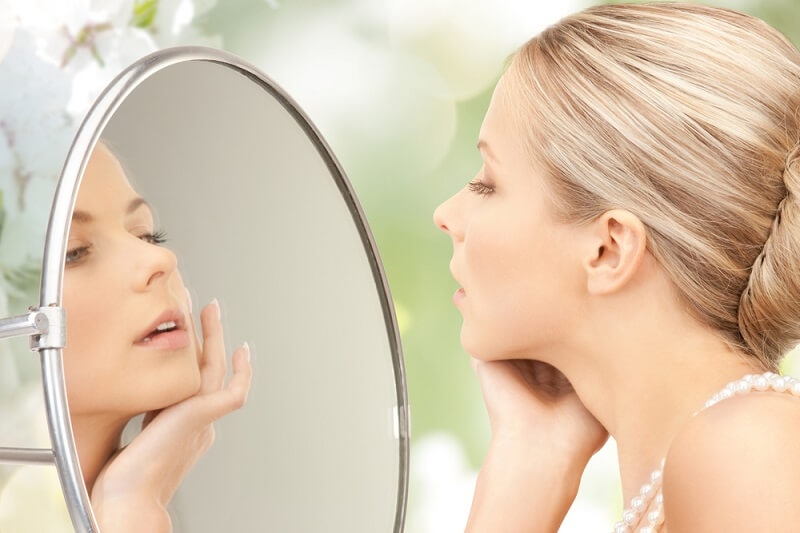 woman looking at mirror