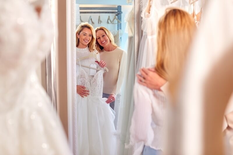 brides looking for her looks in mirror while wearing wedding dress