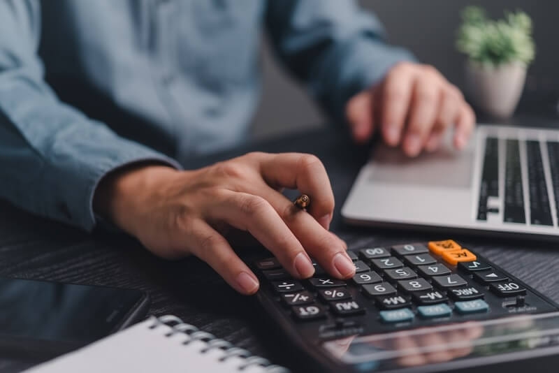 man calculating budget in laptop