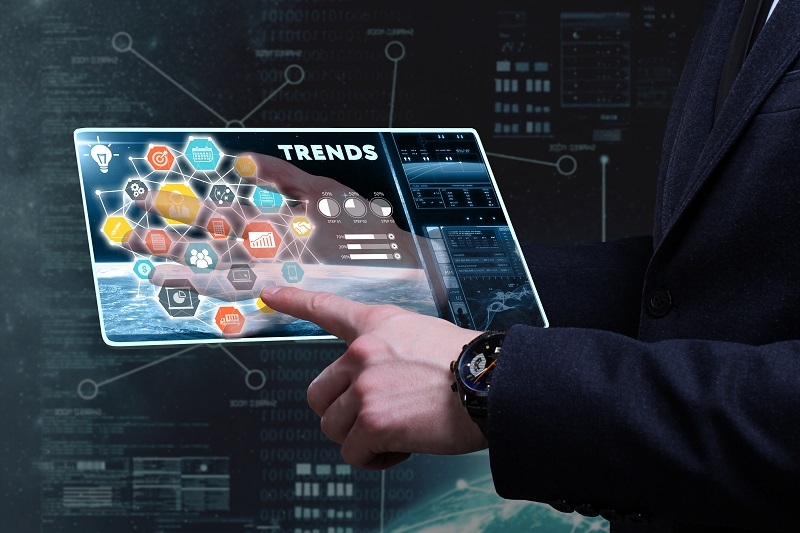 Young businessman working on a tablet of the future, he sees the inscription: trends