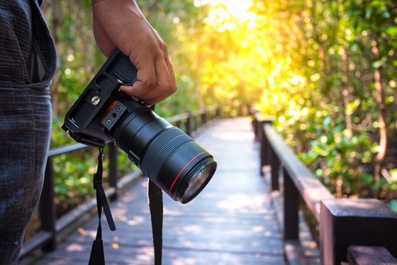 man holding camera for city parks photography'