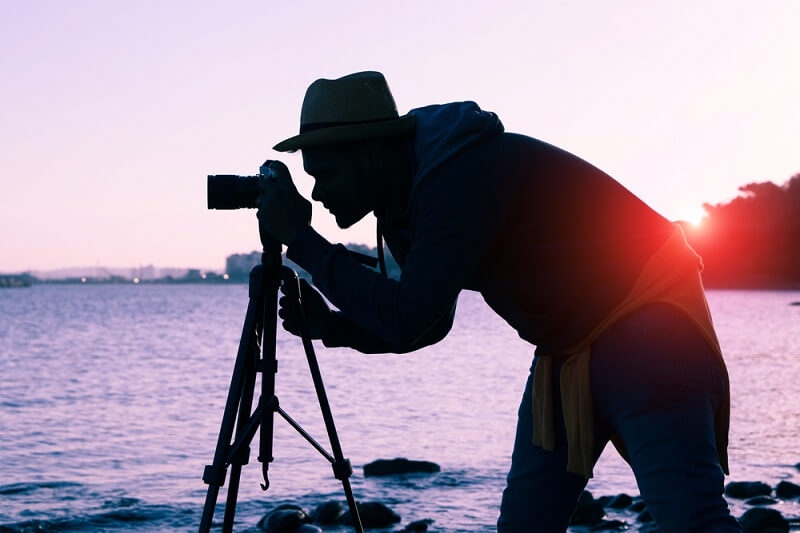 man clicking pictures with camera in low light