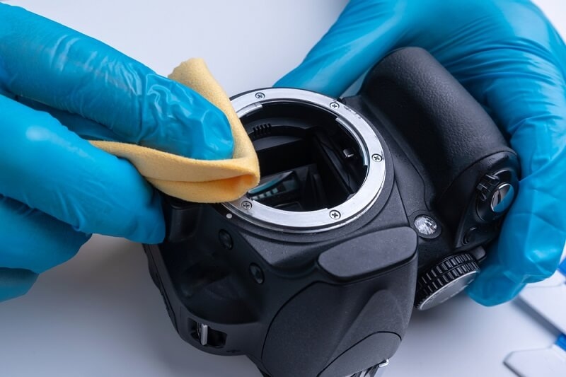 man cleaning camera sensor with soft towel