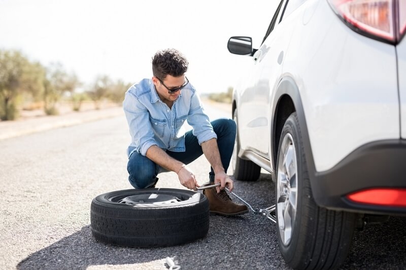 man changing car tyre