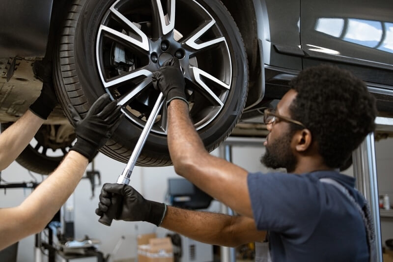 car mechanic checking car steering rode and suspension