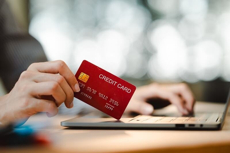 man using credit card for cashback offers on laptop