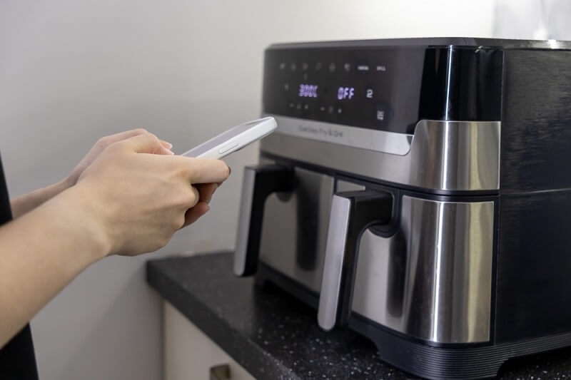 woman using digitally controlled air fryer