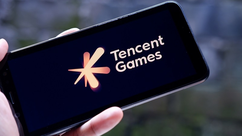 Hand holding smartphone with Tencent Games logo