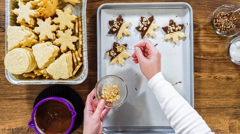 man adding flavors to cookies on tray