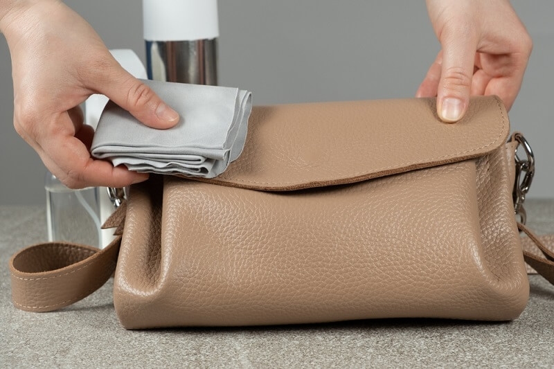 woman cleaning handbag as daily routine