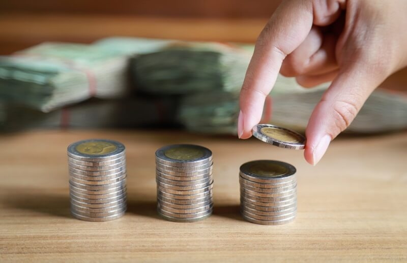 women placing saved coins in a order