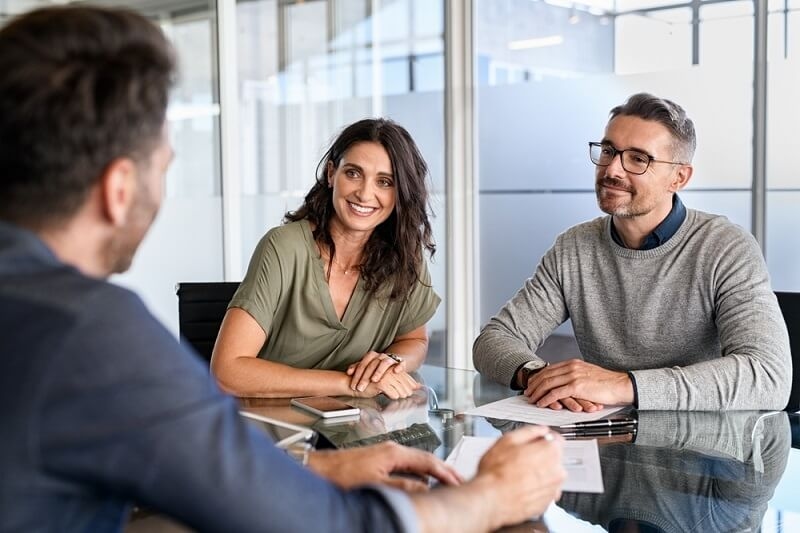 couple visiting bank and talking with bank employees 