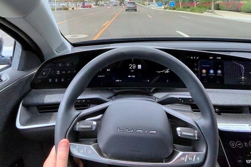 man driving and holding steering of lucid air car