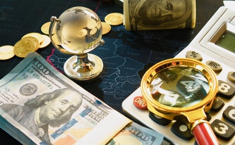 dollars market impact with some dollars and calculator with magnifying glass