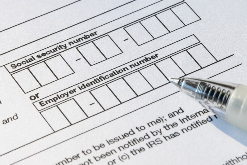 user filling employer identification number in form with pen in hand