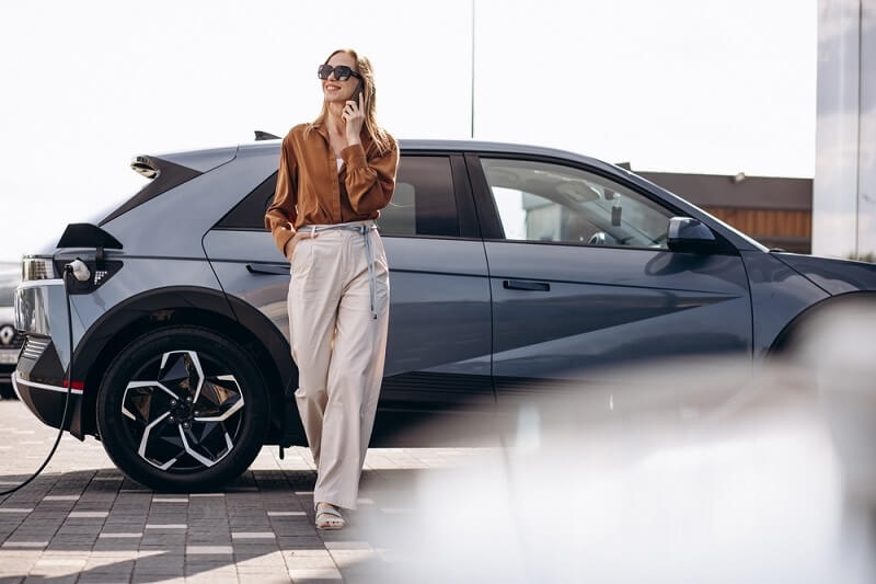woman charging her car in electric station