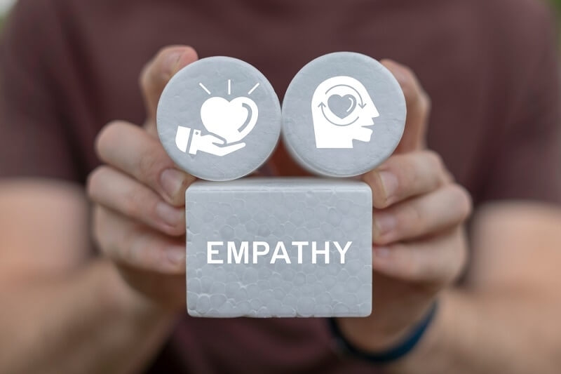 man showing empathy word blocks