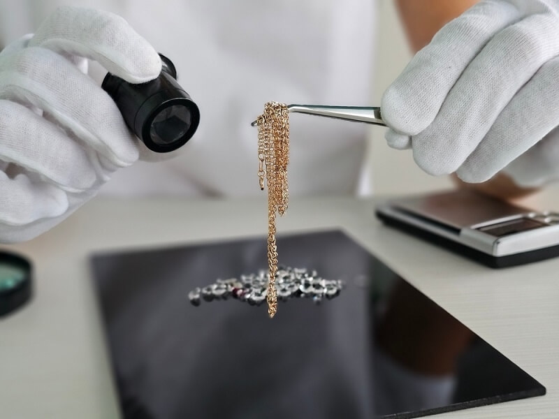 man examining gold jewelry 
