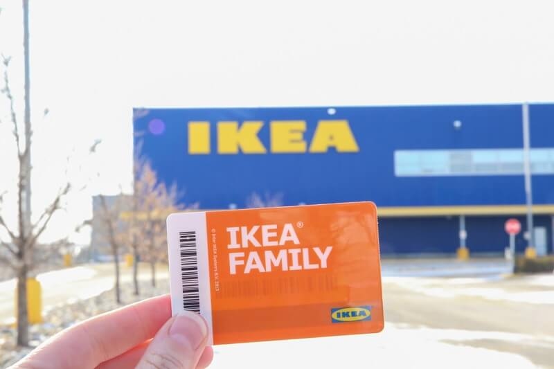 man holding ikea family card in front of ikea store