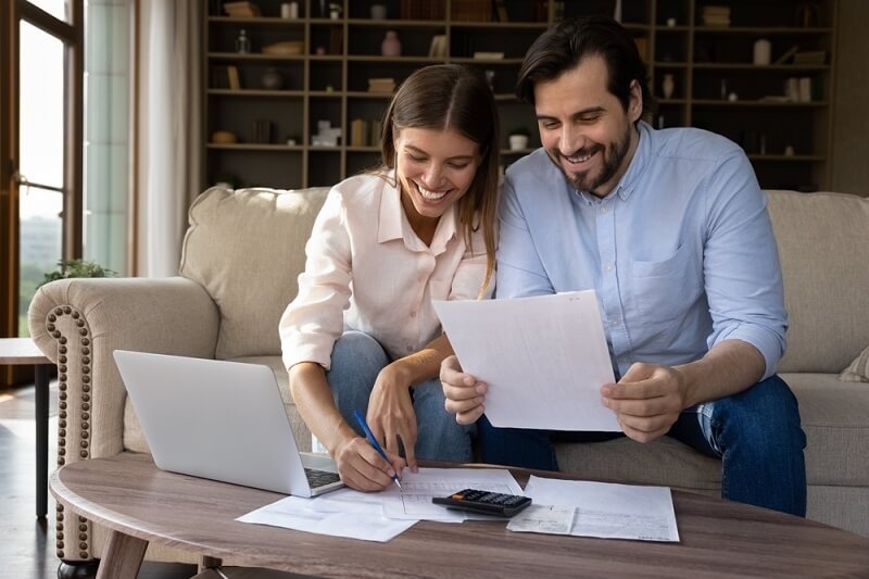 couple smiling and signing form for long term investing for family