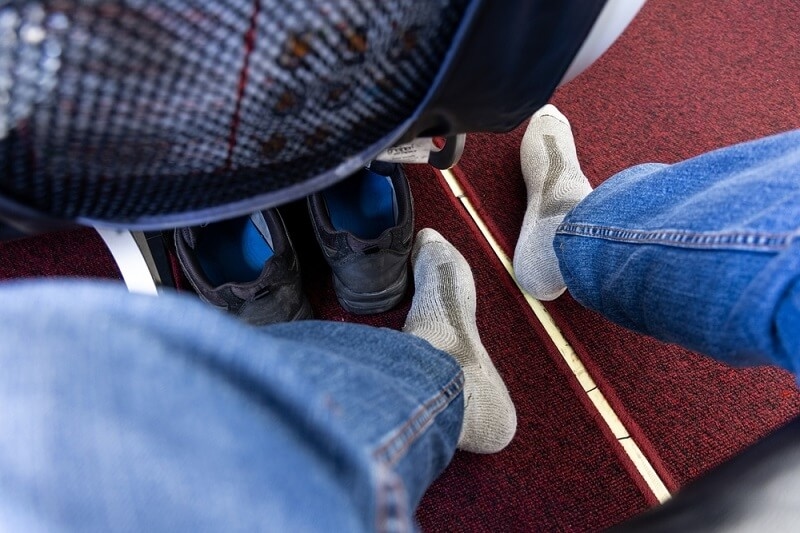 man removed his shoes and sitting relaxed on flight
