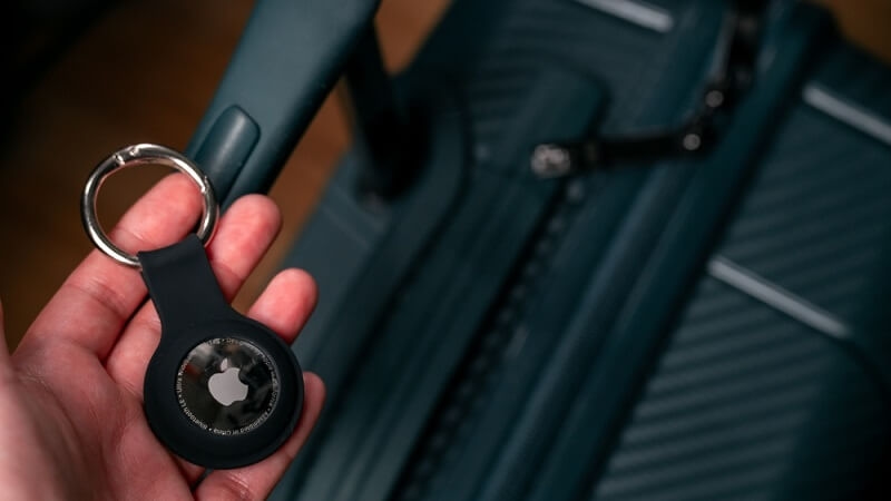 man showing tracker for luggage with bag in background