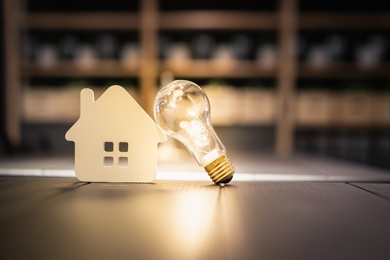 Light bulb with wood house on the table, a symbol for construction, Creative light bulb idea,