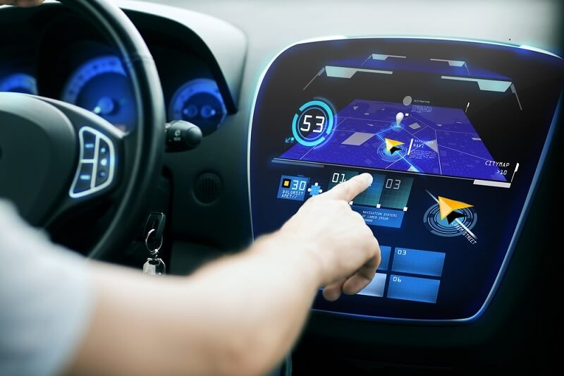 man touching infotainment system in car