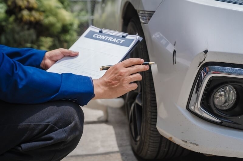 insurance agent checking car damage report