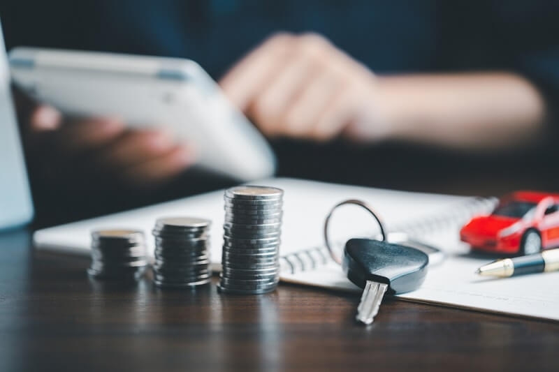 insurance auto with coins and key on table