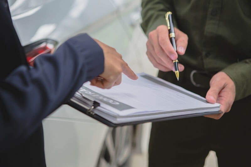 man signing insurance claim form 