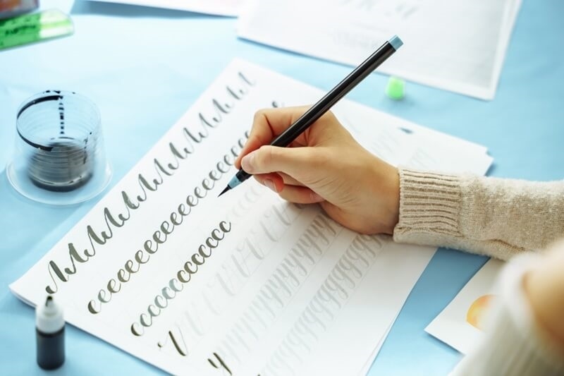 kid-hand-using-calligraphic-pen
