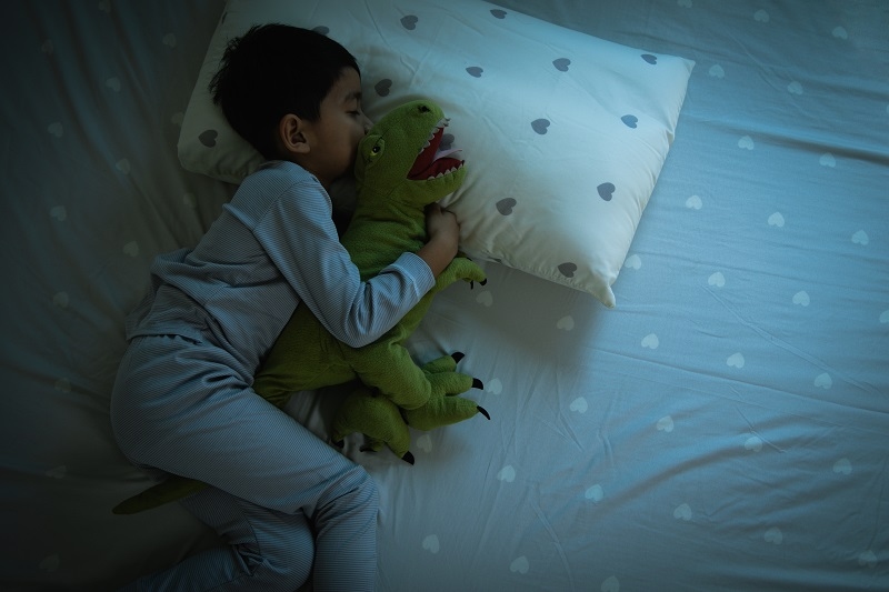 boy having sweet dreams while Sleeping Cozily a Bed in bedroom at home. bedtime, healthy sleep habits concept