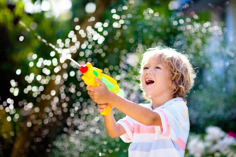 kid playing with water spraying machine