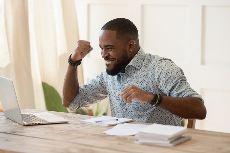 man getting excited over promotion from online learning