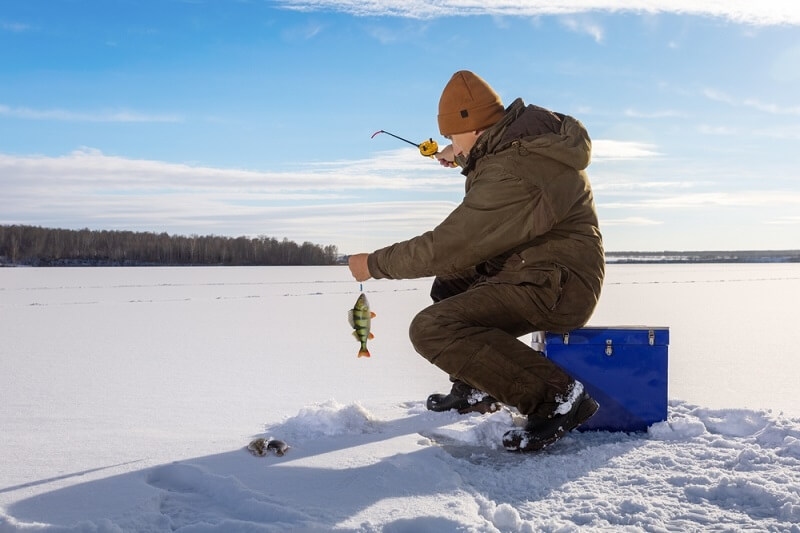 man doing jigging ice fishing on ice 