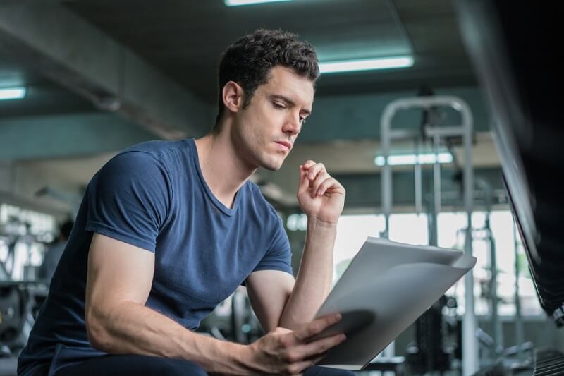 man working in gym following workout plan