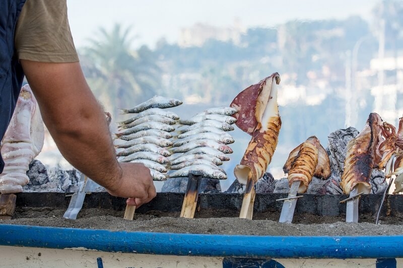 man grilling sardines in style