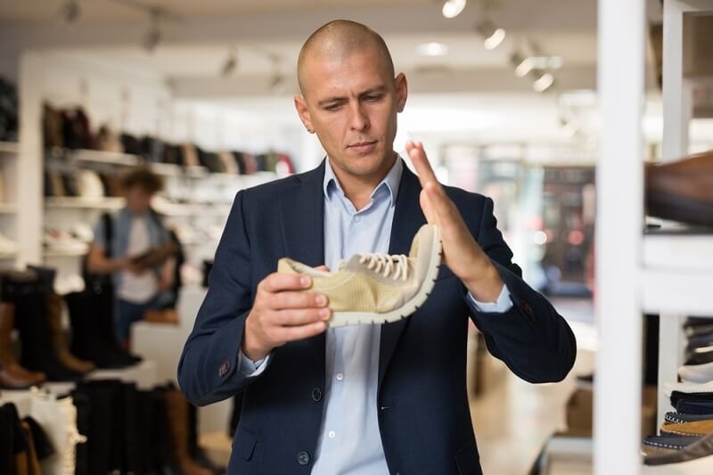 man checking shoe quality and durability before buying