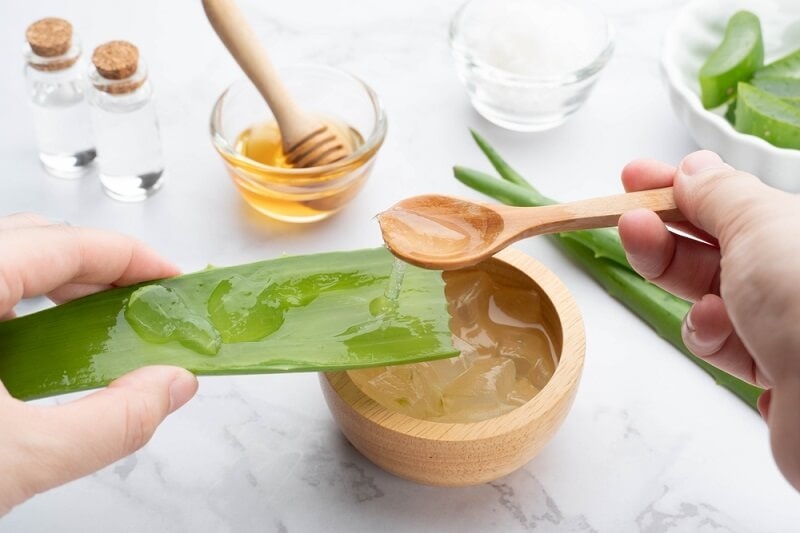 woman preparing face mask with aloe and honey ginger