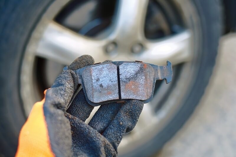 mechanic-holds-hand-bad-brake-pad
