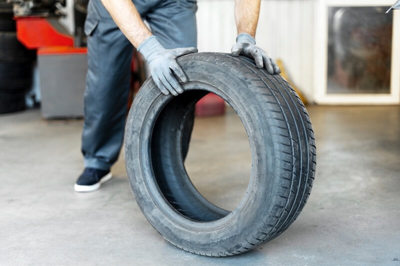mechanic checking tyre wearing gloves