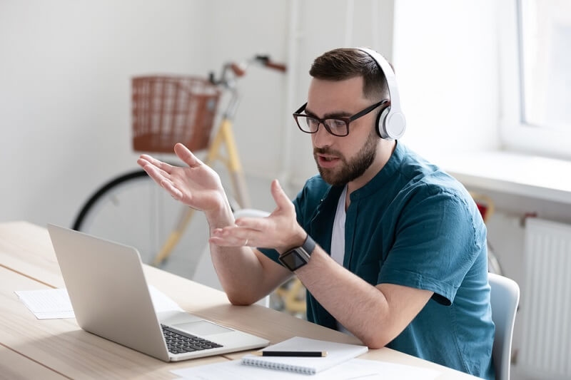 man wearing headphones working on laptop work from home