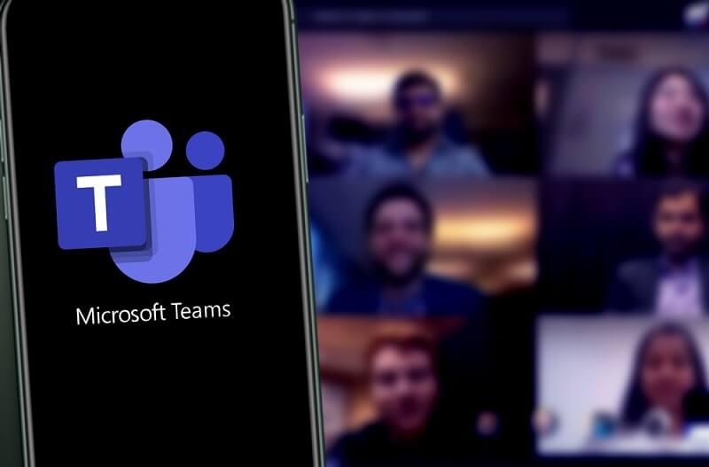 microsoft teams on smartphone and meeting in background