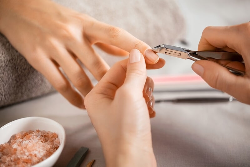 woman using tool for cleaning cuticles