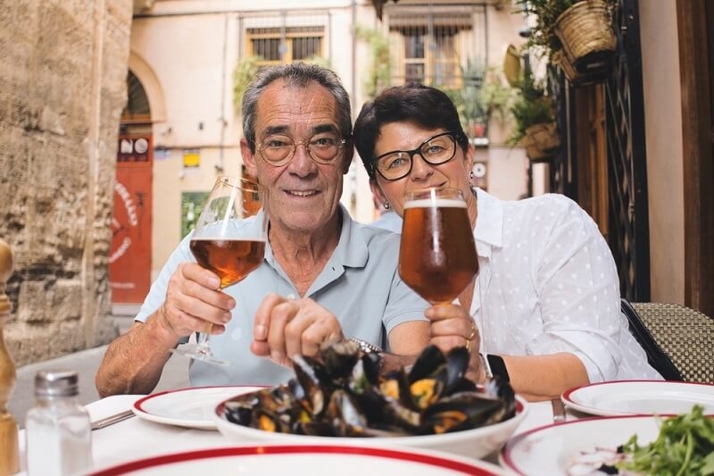 old couple having lunch and wine in spain