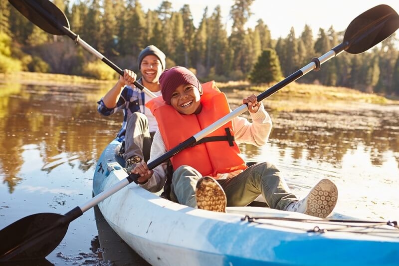 kid paddleboarding with his father