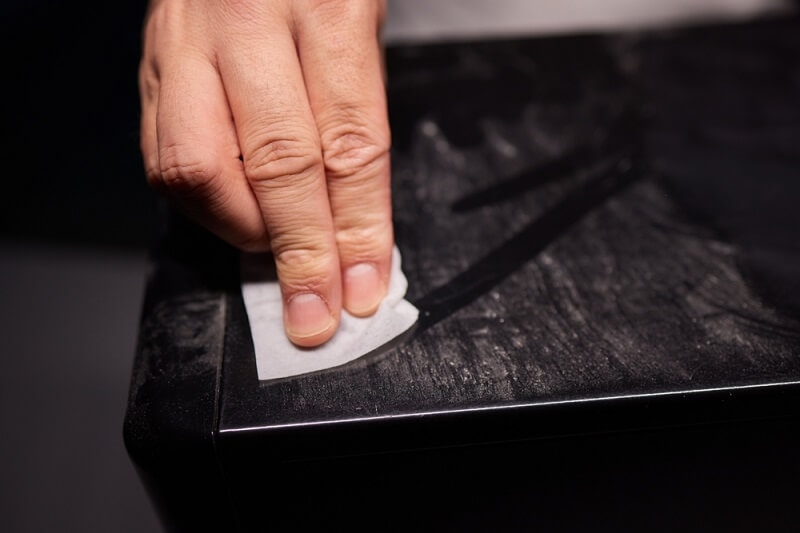 man cleaning pc with hand towel