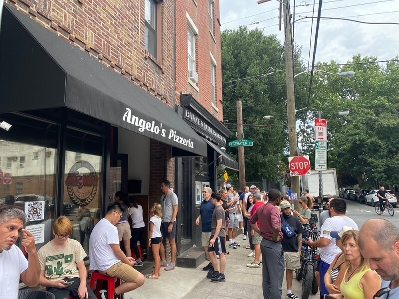 people ordering cheese steak at store