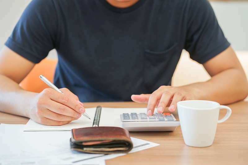 man hand write list of debt on notebook and calculate personal budget plan